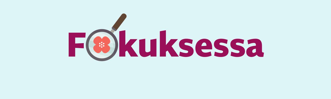 Kuvassa teksti Fokuksessa. O-kirjain korvattu suurennuslasilla, jonka sisällä annansilmät-kukka.